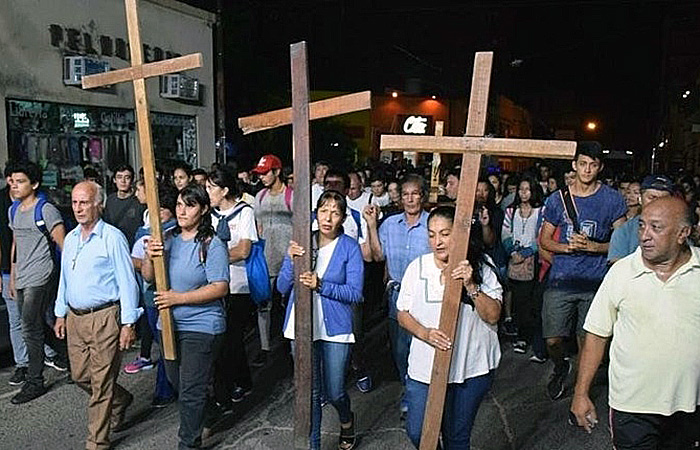 Fieles participando en el Vía Crucis Interprovincial entre Corrientes y Chaco durante la noche