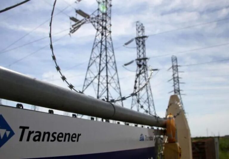 Torres de alta tensión y líneas de transmisión eléctrica en el campo, representando la red de Transener.
