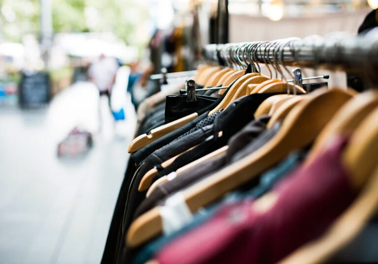 Local comercial vacío con persiana baja en la vía pública, reflejo de la crisis textil