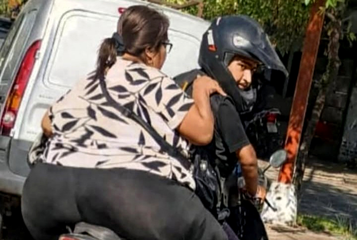 Motocicleta con conductor y pasajero, ilustrando el tema de la capacidad de carga y seguridad vial.