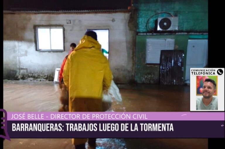 Trabajadores municipales asistiendo en una calle anegada de Barranqueras tras el temporal
