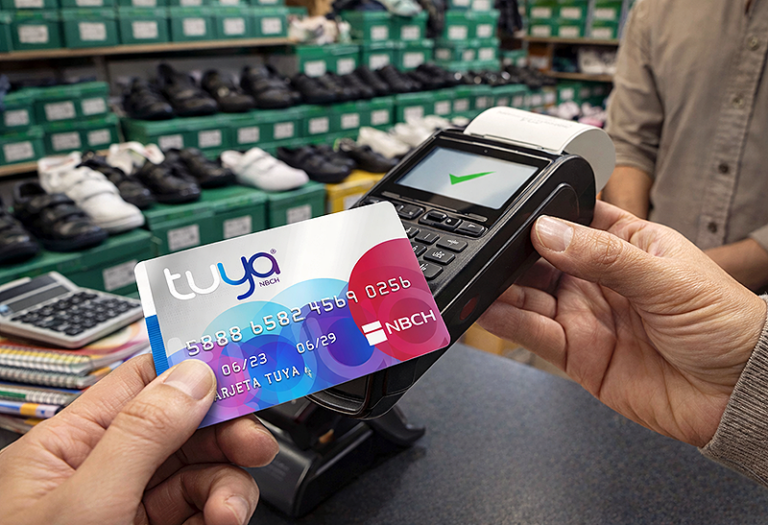 Tarjeta Tuya del Nuevo Banco del Chaco sobre fondo de compras en Sarmiento Shopping, Resistencia.