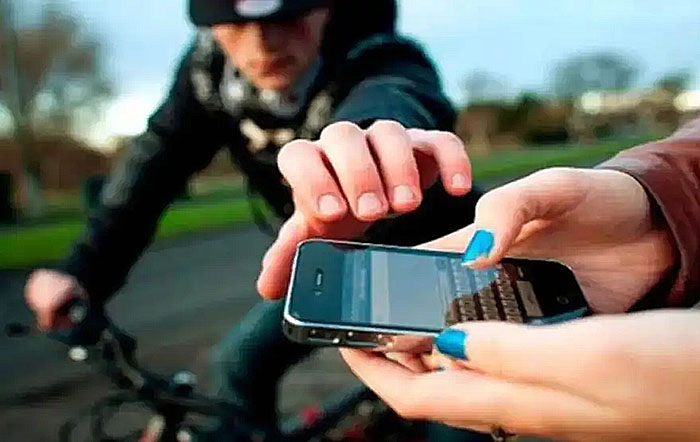 Persona sosteniendo un celular con un símbolo de candado, representando la seguridad móvil.